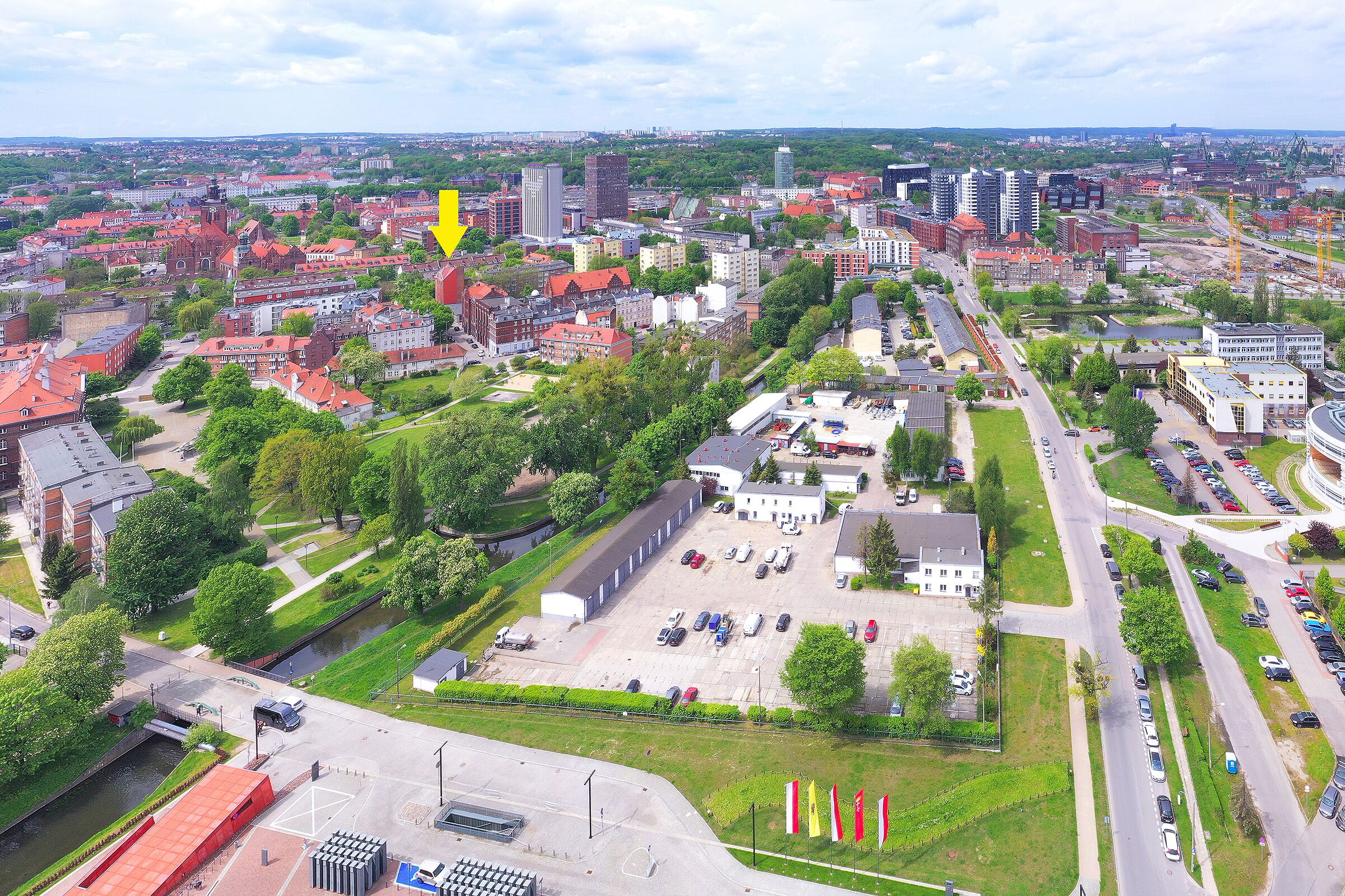 Vista aérea de un paisaje urbano con diversos edificios, carreteras y zonas verdes.