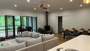 Una sala de estar moderna con un sofá, una mesa de comedor y una zona de cocina con un fregadero.