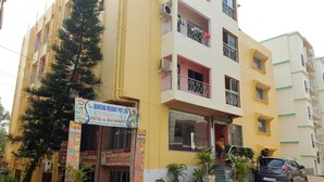 Un hotel de varios pisos con balcones y un letrero que anuncia un restaurante.
