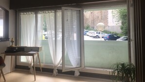 Huone, jossa on suuri ikkuna, työpöytä ja tuoli.