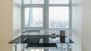 A room with a large window, a black table, and a trash bin. - 2 Bed Duplex close to Millennium Sq (Leeds)