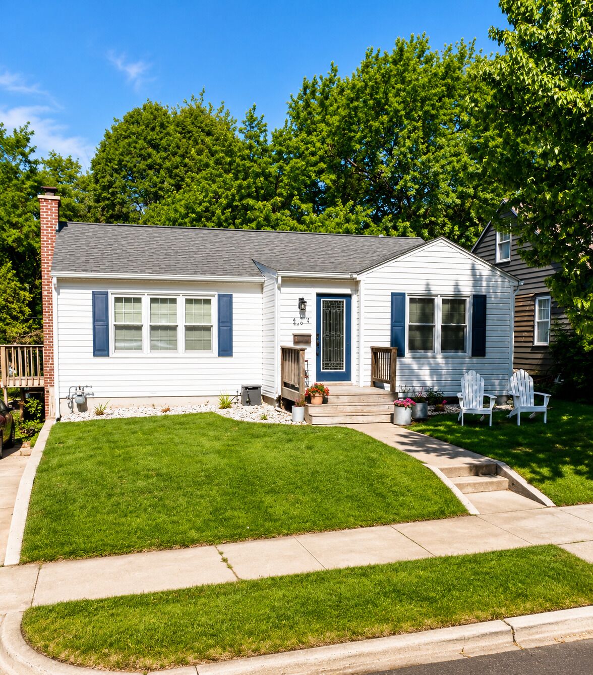 A two-story house with a front porch, a small attached garage, and a well-maintained lawn.