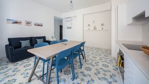 Un espacio habitable pequeño con comedor, sofá y cocina.