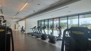 Un gimnasio con cintas de correr, elípticas y equipos de pesas.