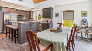 Una cocina amplia con una isla grande, armarios de madera oscura y electrodom ésticos de acero inoxidable.