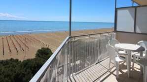 Un balcon avec vue sur la plage et l’océan.