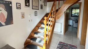 A staircase with wooden railings and a tiled floor leading to a room with a radiator and a window. - Anklam Stolpe near Anklam (Stolpe an der Peene)