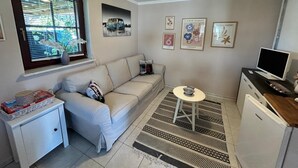 A compact living space with a sofa, a small table, a TV, and a refrigerator. - Anklam Stolpe near Anklam (Stolpe an der Peene)