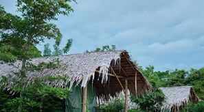 A traditional thatched-roof structure surrounded by lush greenery. - Forest Lodge Eco Camp  (Rankethgama)