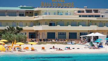 Ein Hotel mit Blick auf den Strand, mehreren Balkonen und Sitzbereichen im Freien.
