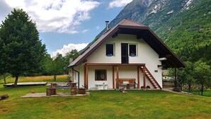 A two-story house with a sloped roof, a front porch, and a small staircase leading to the entrance. - Soča Home With The View (Bovec)