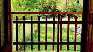 A wooden balcony with a view of a forested landscape. - Soča Home With The View (Bovec)