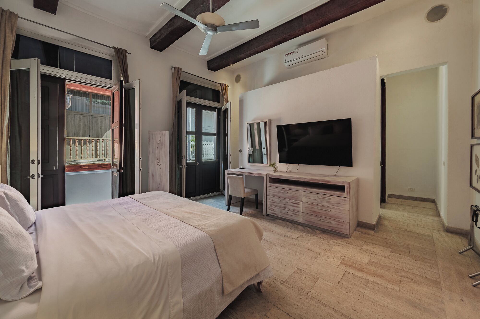 Une chambre à coucher comprenant un lit, un bureau, une télévision et une armoire.