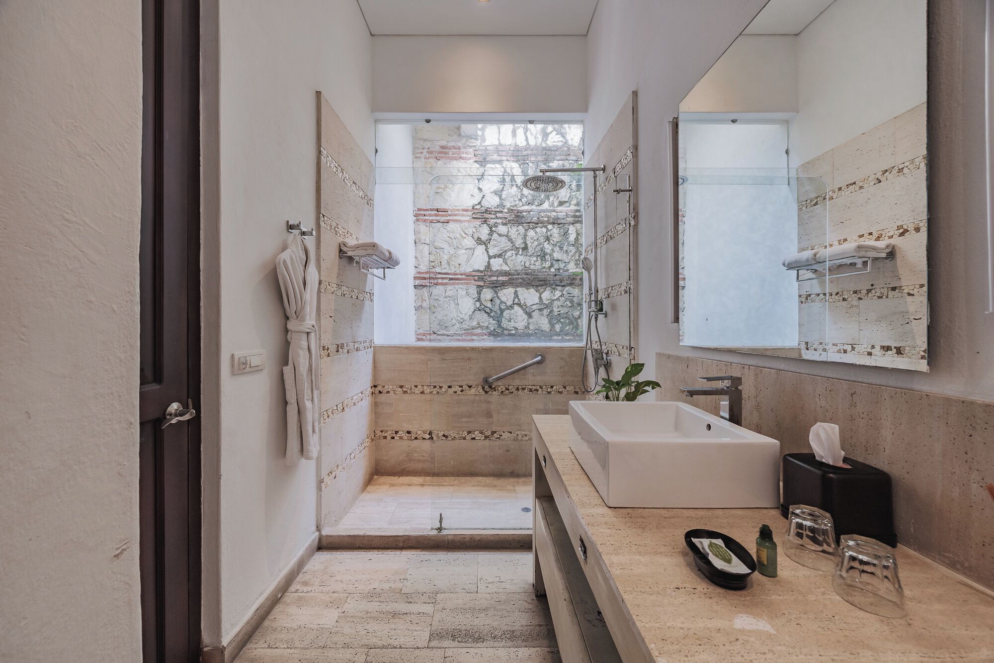 A modern bathroom with a large mirror, a bathtub, and a shower.