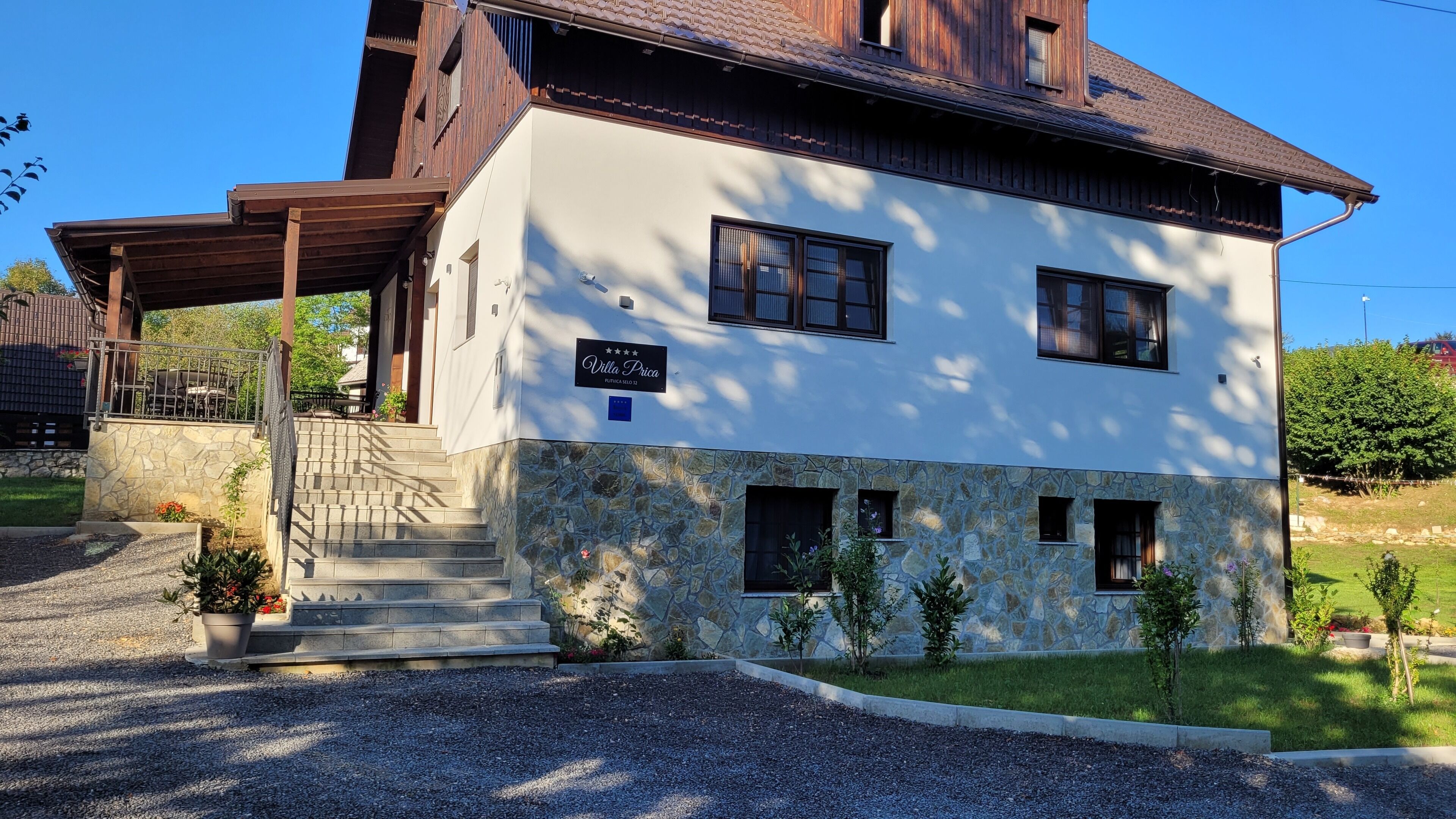 A two-story building with a stone facade, a covered porch, and a sign reading "Villa Prica."