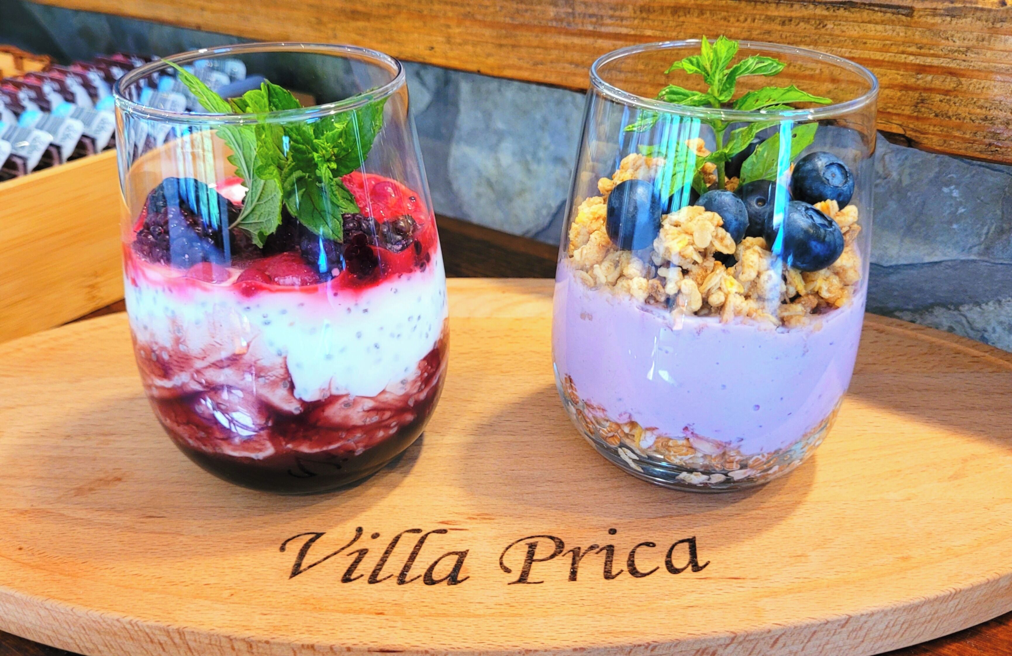 Dois copos de parfait sobre uma tábua de madeira com o texto "Villa Prica".