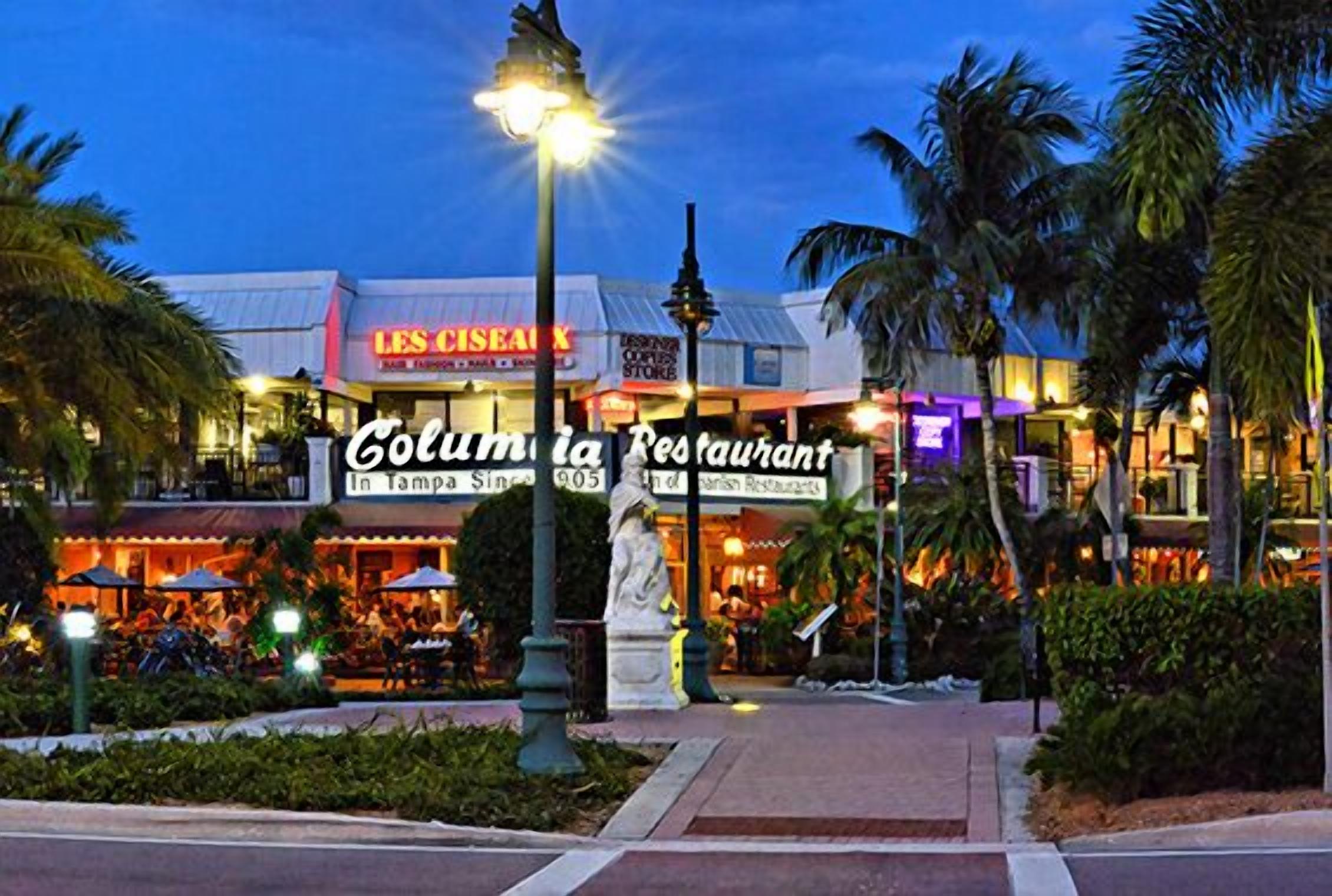 Un restaurante con terraza y palmeras.