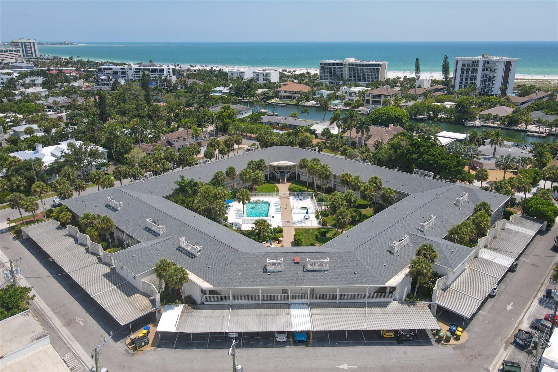 Un hotel grande de varios pisos con un patio central que tiene una piscina.