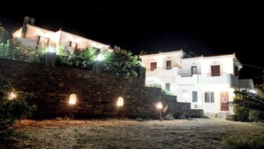 Ein zweistöckiges Gebäude mit Steinmauern und zahlreichen Fenstern, beleuchtet in der Nacht.