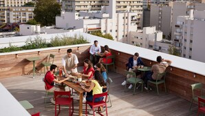 A rooftop terrace with a group of people dining. - Hife Paris Gentilly (Gentilly)