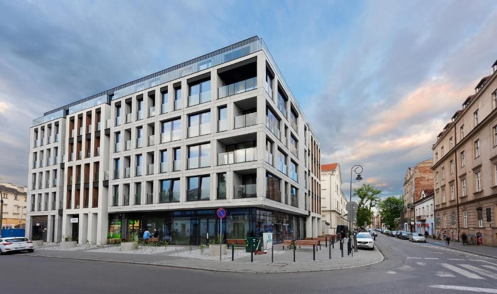 A modern building with a corner entrance, large windows, and a flat roof.