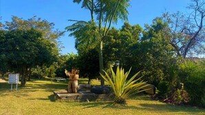 A well-maintained garden with a variety of plants and a central sculpture. - Cosy studio with kitchenette in Norton - 2120 (Norton)