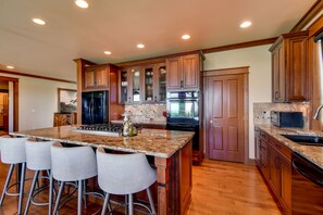 A kitchen with wooden cabinets, a granite countertop, a stainless steel refrigerator, and a built-in oven. - Port Angeles Home: 7 Mi to Olympic Natl Park! (Port Angeles)