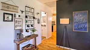 Una cucina con angolo caffè, porta pentole a parete e un cartello con su scritto 'restiamo a casa e coccoliamoci'.