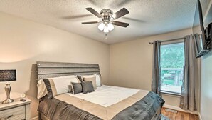 A bedroom with a bed, bedside table, lamp, and a ceiling fan. - Lillington Home ~ 1 Mi to Cape Fear River! (Lillington)