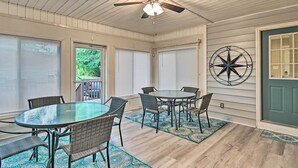 A dining area with a round glass table and wicker chairs, a ceiling fan, and a decorative compass wall art. - Lillington Home ~ 1 Mi to Cape Fear River! (Lillington)