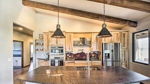 A spacious kitchen with a large island, wooden cabinets, stainless steel appliances, and pendant lighting. - Pastoral Elgin Escape w/ Covered Patio & Grill! (Elgin)