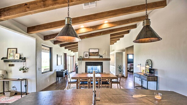 A spacious kitchen with a central island, wooden beams, pendant lighting, and a fireplace. - Pastoral Elgin Escape w/ Covered Patio & Grill! (Elgin)