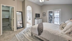 Ein Schlafzimmer mit Bett, Deckenventilator, Kommode und Fernseher.