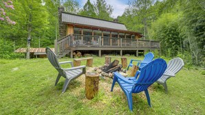 A cabin with a deck, surrounded by a grassy area and trees. - Hot Tub, Fire Pit: Waynesville Getaway Near Hiking (Canton)