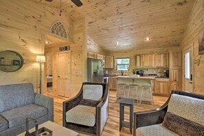 A cozy cabin interior with a dining area, kitchen, and a living room with a sofa and armchairs. - Private Hot Tub & EV Charger: Cozy Murphy Cabin! (Murphy)