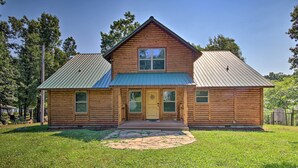 A two-story log cabin with a green metal roof, a front porch, and a stone pathway leading to the door. - 'rukarasa Cabin' w/ Yard & Dock at Grand Lake (Eucha)