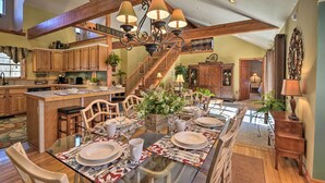 Une cuisine spacieuse avec des meubles en bois, un îlot central et un lustre.