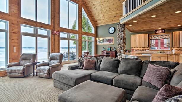 A spacious living area with a large sectional sofa, a dining table, and a kitchen area with a coffee station.