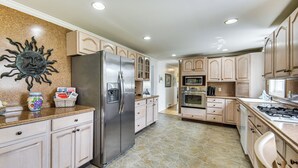 A kitchen with a refrigerator, microwave, stove, and cabinets. - Charming Painter Home w/ Chesapeake Bay Views (Painter)