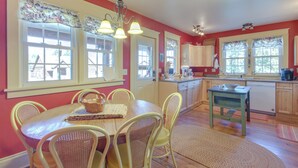 Una cocina con una mesa de comedor, sillas y lavavajillas.