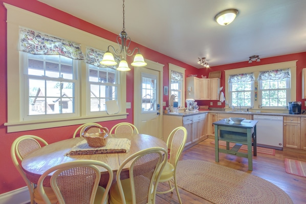 A kitchen with a dining table, chairs, and a dishwasher.