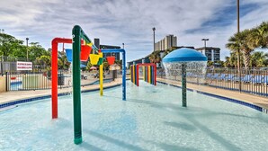 Uma área de recreação com água, estruturas coloridas e uma cúpula azul.