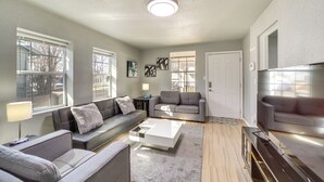 A modern living room with a sectional sofa, a coffee table, and a TV stand. - Convenient Tulsa Home - 2 Mi to Downtown! (Tulsa)