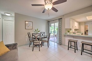A dining area with a round table and chairs, a ceiling fan, and a kitchen area with a counter and stools. - 3 Mi to Wekiwa Springs! Apopka Family Home (Apopka)