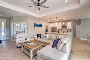 A spacious living room with a beige sofa, a wooden coffee table, and a ceiling fan. - 5 Mi to Beach & Walk to Park: Modern Venice Home (Venice)