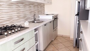 A modern kitchen with a gas stove, stainless steel appliances, and light wood cabinetry. - Casa Vacanze da Vicenta (Camerota)