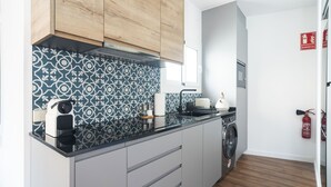 A modern kitchen with a washing machine, a coffee maker, and a toaster.