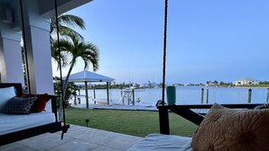 A balcony with a bed and a view of the sea.