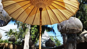 A thatched roof structure with a central umbrella. - Appt "chrisanne" 3 T2 Grande Terrasse à St Gilles (Saint Paul)