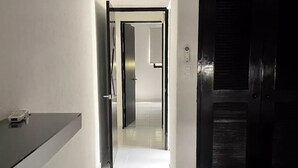 Ett hotellrum med en säng, ett skrivbord och ett badrum som syns genom en öppen dörr.